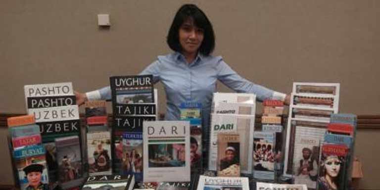 Woman at a table showing off a collection of books and brochures