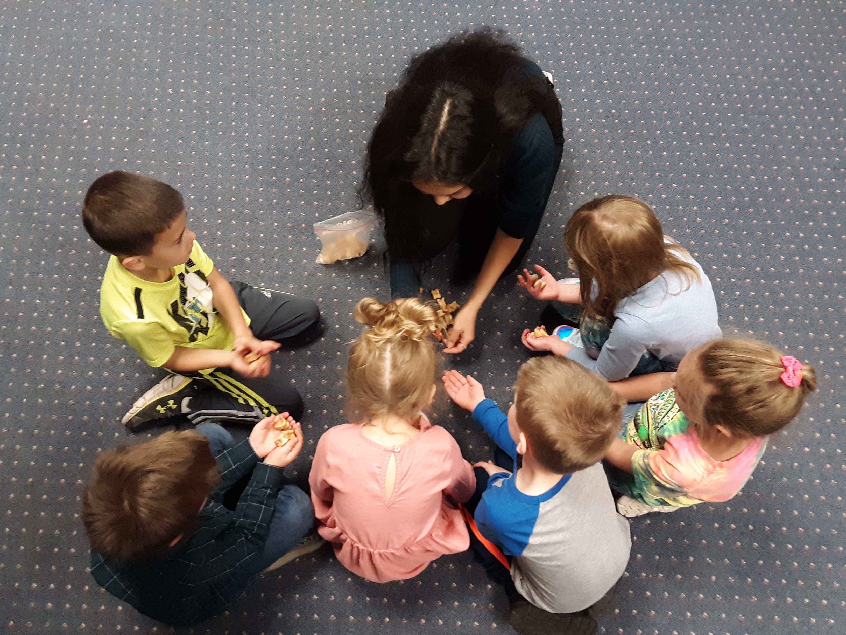 Woman doing activity with kids in a circle