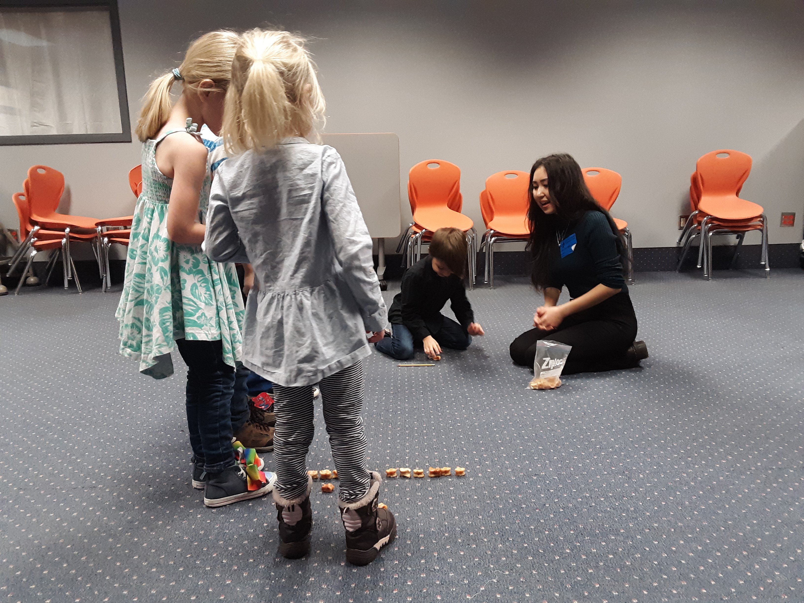 Woman doing activity with kids in a room