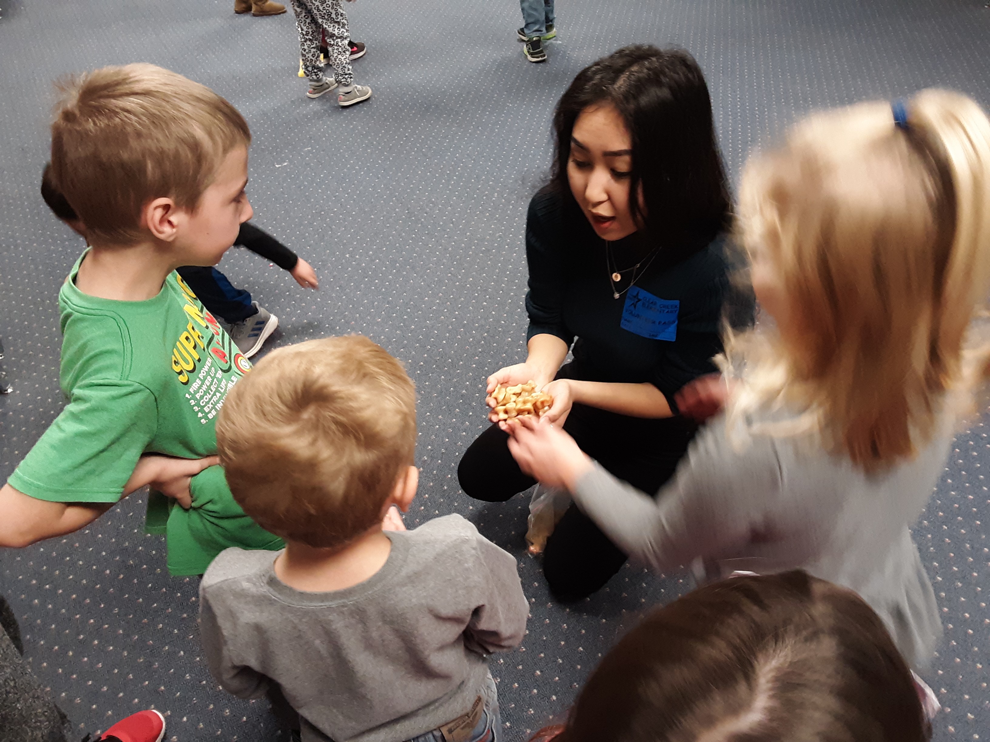 Woman doing activity with kids in a room in a circle