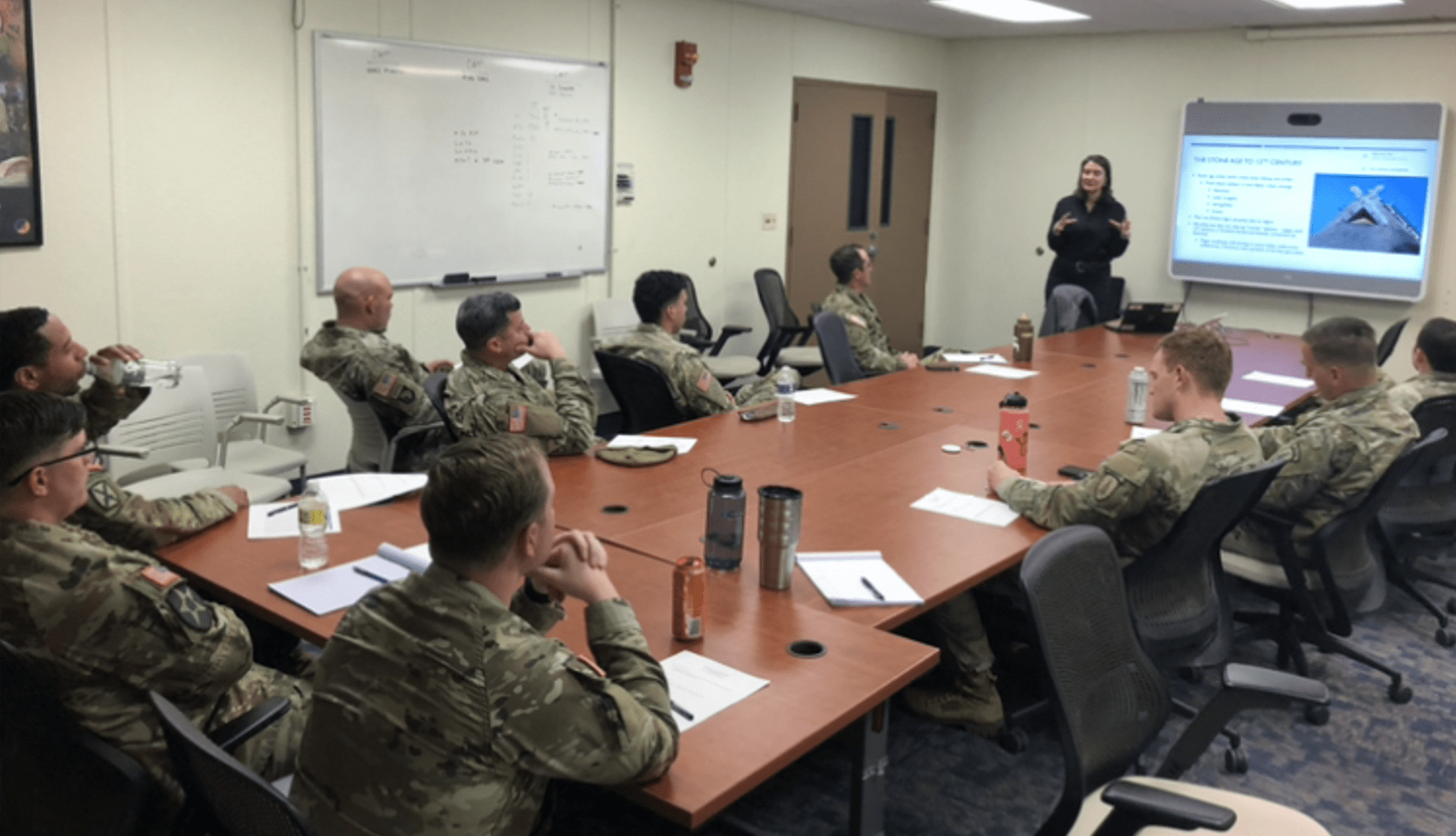 Young woman giving a presentation to a group of US troops