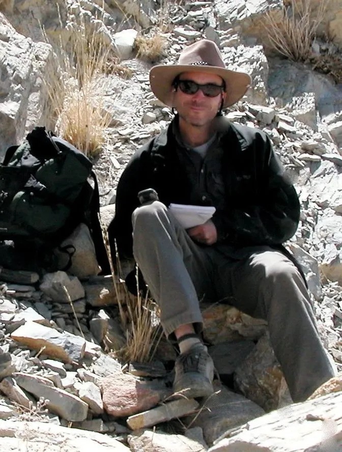 Dr. Andrew Quintman sitting on some rocks