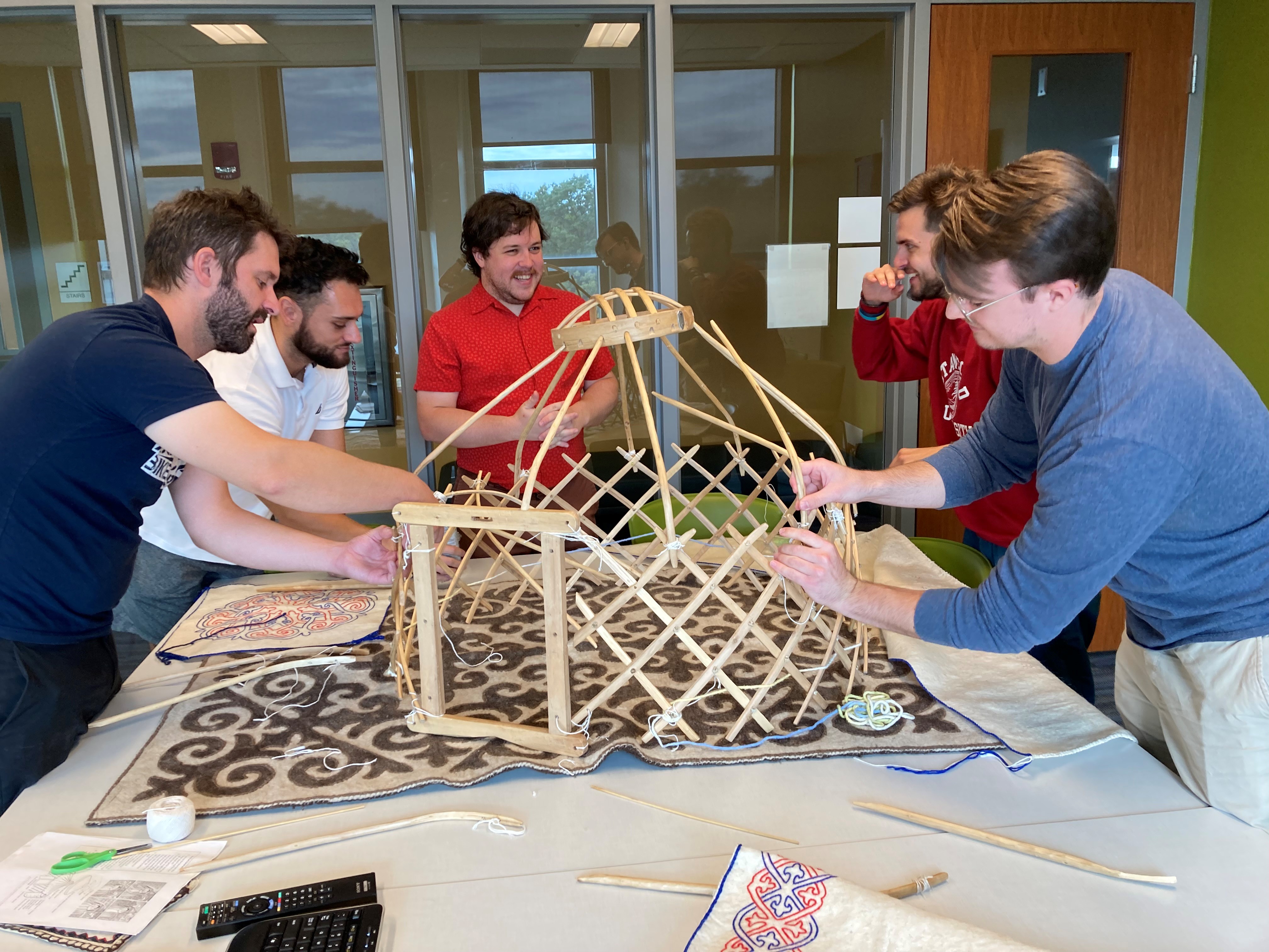 Graduate assistants practice erecting the model yurt in preparation for visiting Edgewood Junior High